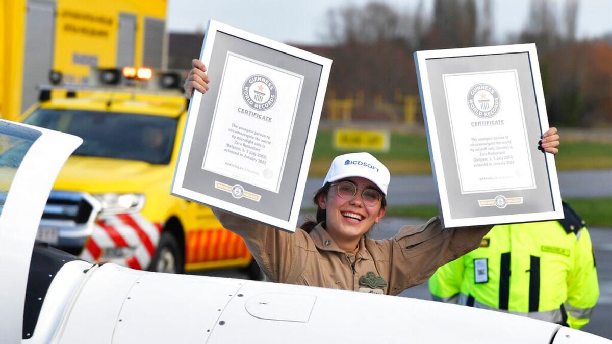 Zara Rutherford holds up her certificates after landing her Shark ultralight plane at the Kortrijk airport in Kortrijk, Belgium. – AP