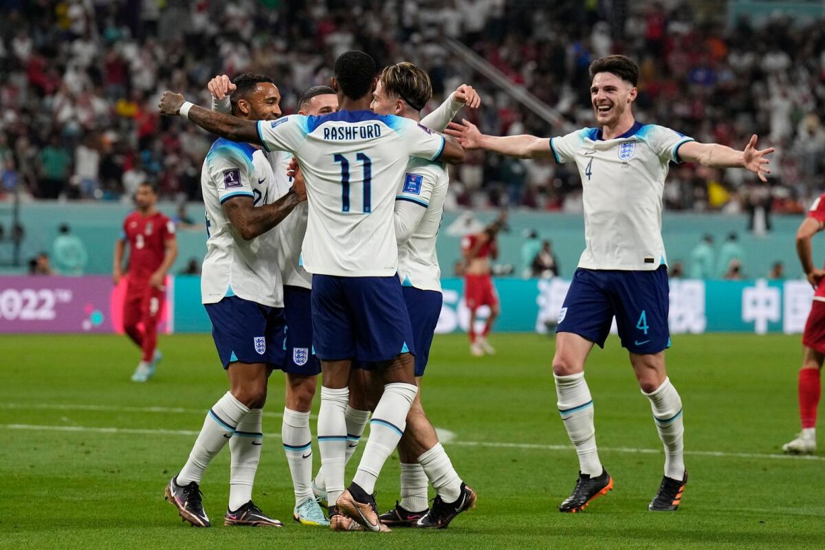 England players celebrate after scoring against Iran in Doha. — AP