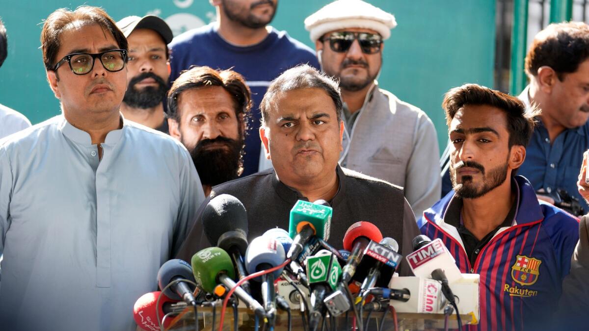 Fawad Chaudhry, centre, a leader of former prime minister Imran Khan's party, talks to media outside the Election Commission head office in Islamabad. — AP file