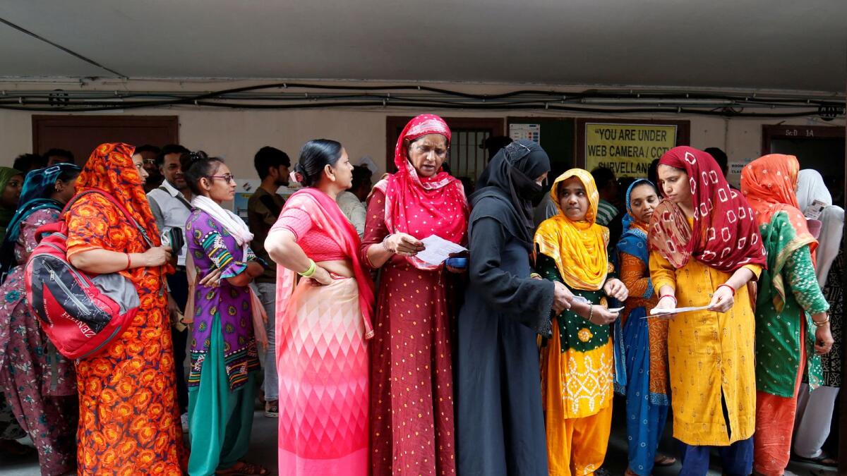 People wait in queues to cast their votes at a polling station. Photo: Reuters