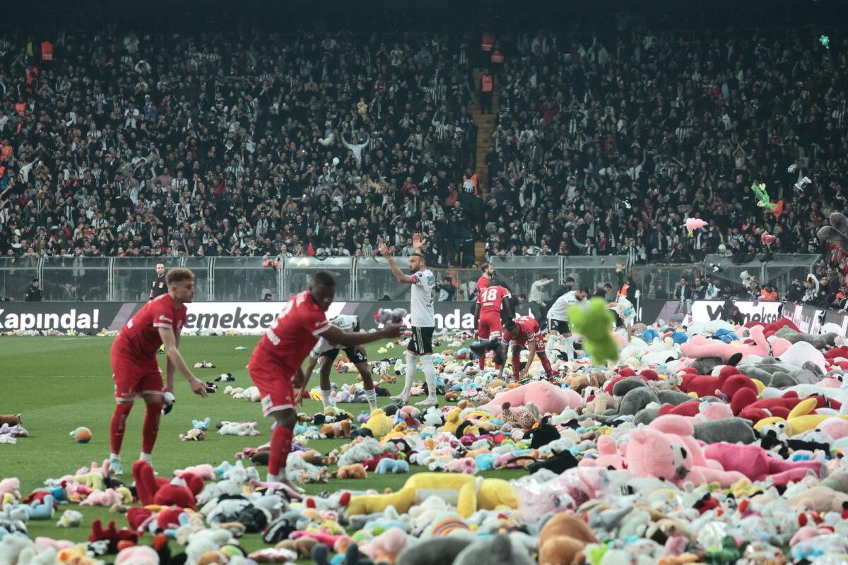 Fans throw toys on the pitch for children affected by earthquake during a Turkish Super League match. Photo: Reuters