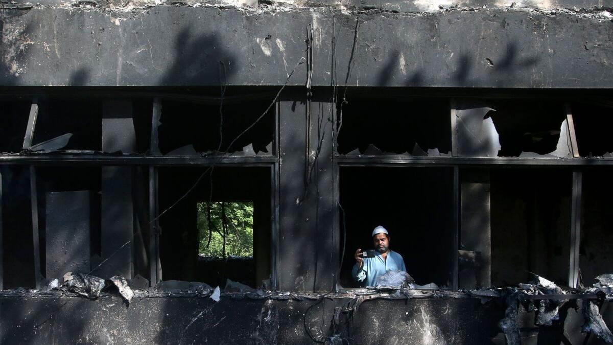 A man takes a photo with his mobile phone inside the Radio Pakistan building burnt in Wednesday's clashes between police and the supporters of Pakistan's former Prime Minister Imran Khan, in Peshawar, Pakistan, Thursday, May 11, 2023. — AP file