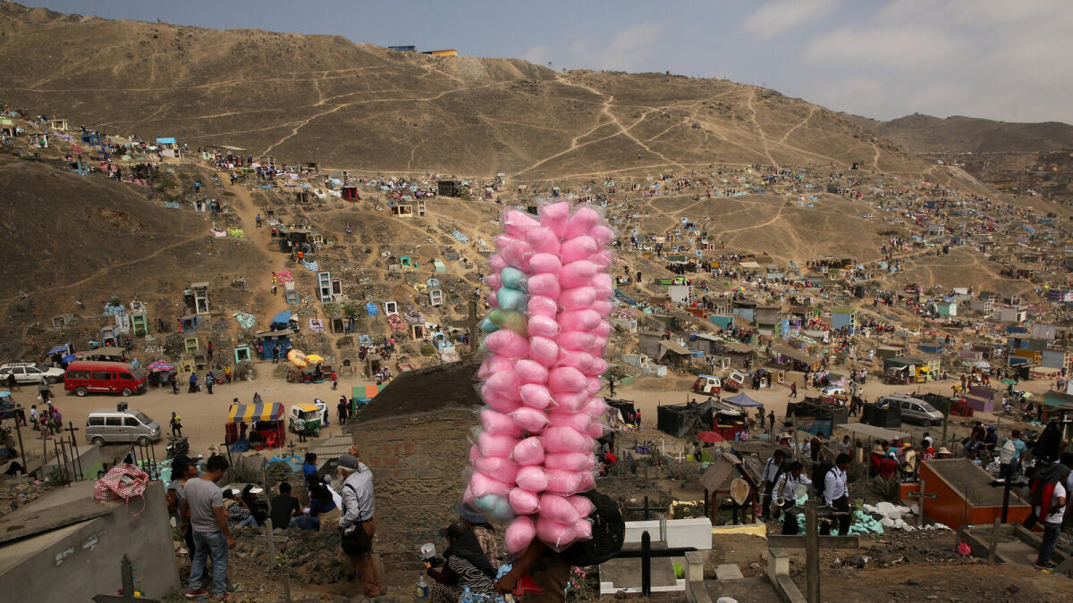Street vendor sells candy floss as people visit tombs of relatives and friends at 'Nueva Esperanza' (New Hope) cemetery during the Day of the Dead celebrations in Villa Maria del Triunfo on the outskirts of Lima, Peru, November 1, 2016. Reuters