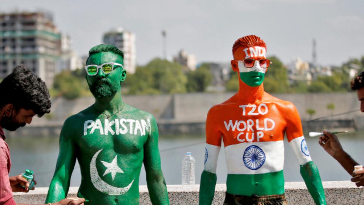 Cricket fans get their bodies painted with the Indian and Pakistani national flag colours, ahead of the T20 World Cup match between the nations in Dubai. – Reuters