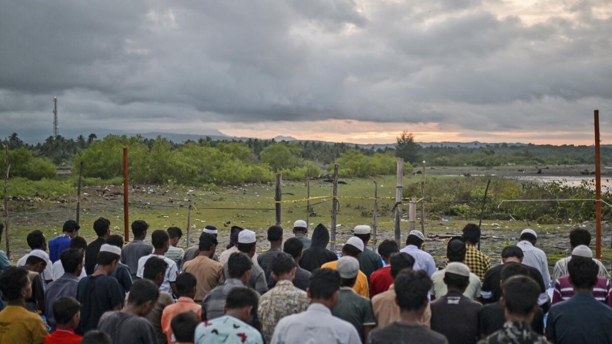 Ethnic Rohingya men perform a dusk prayer at their camp in Pidie, Aceh province, Indonesia. — AP