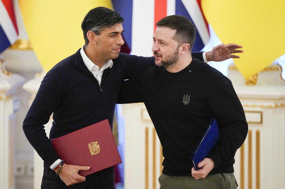 Rishi Sunak hugs Volodymyr Zelensky after signing documents in Kyiv. — AP