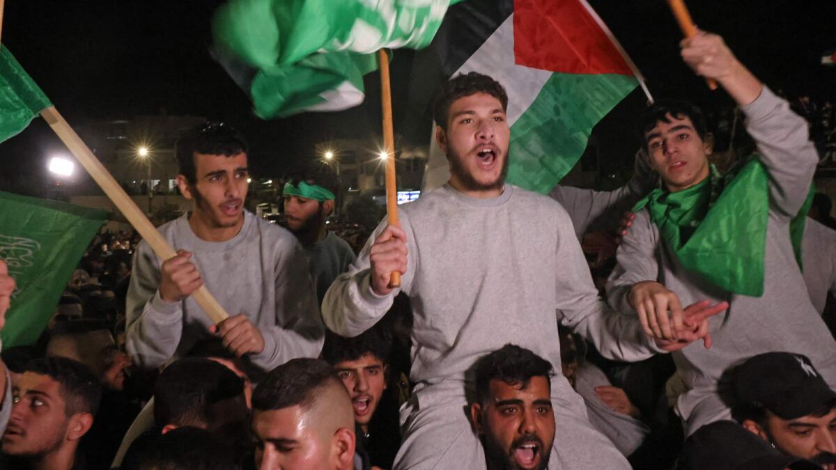 Palestinian prisoners (wearing grey jumpers) cheer after being released from the Israeli Ofer military facility in Baytunia near the city of Ramallah in the occupied West Bank in exchange for hostages freed by Hamas in Gaza, on November 24, 2023. AFP