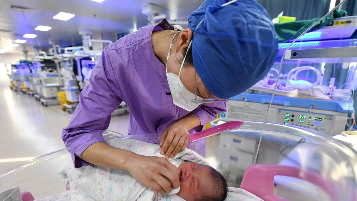 A nurse takes care of a newborn baby at a hospital in Fuyang, in China's eastern Anhui province on Tuesday. — AFP