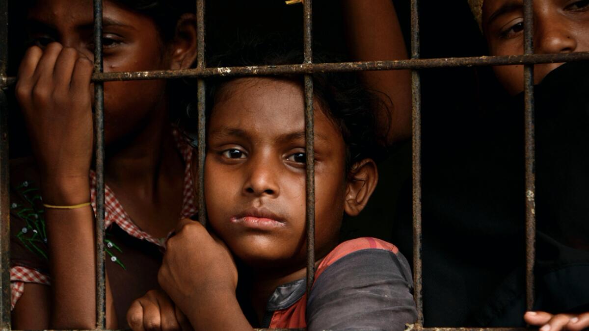 Rohingya people from Myanmar look outside a fence at the immigration detention centre in Lhokseumawe in Indonesia's North Aceh Regency. Photo: AFP