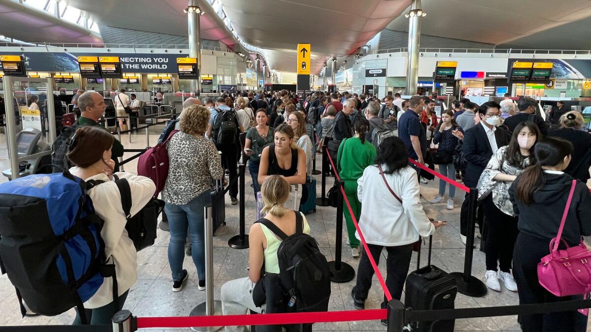 Travellers queue at security at Heathrow Airport in London. –AP