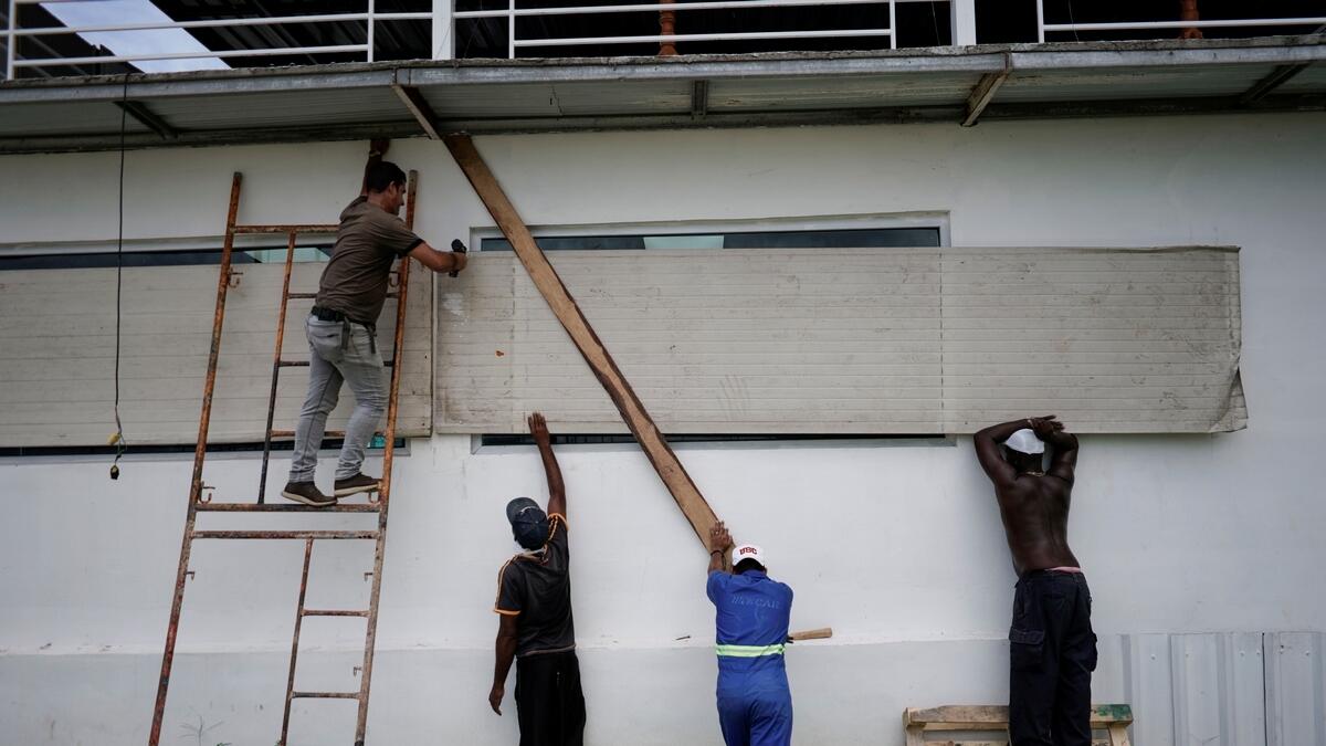 Workers protect the windows of a bar in anticipation of the Tropical Storm Laura arrival, in Havana, Cuba, August 24, 2020.