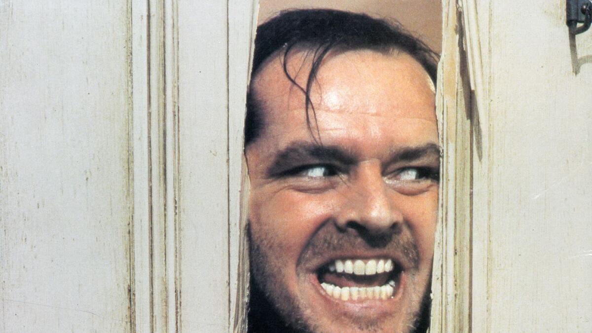 Jack Nicholson peering through axed in door in lobby card
