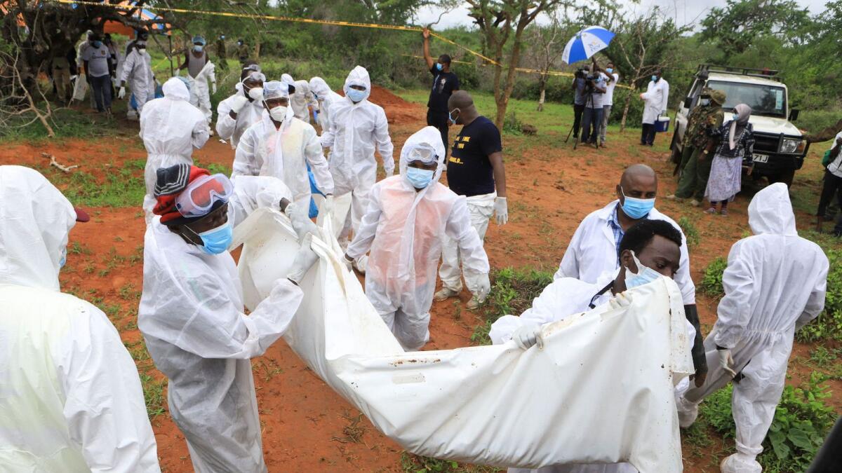 Forensic experts and homicide detectives carry the bodies of suspected members of a Christian cult named as Good News International Church in Shakahola forest of Kilifi county, Kenya. — Reuters