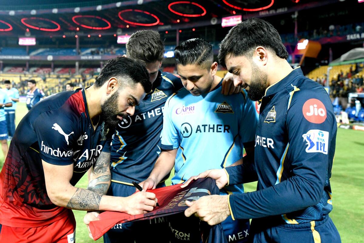 Virat Kohli signs a jersey for Rashid Khan after the match between Royal Challengers Bangalore and the Gujarat Titans. — IPL