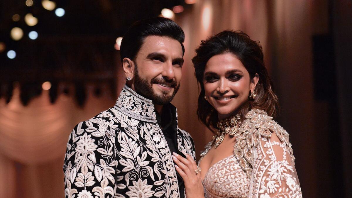 In this picture taken on July 29, 2022, Bollywood actors Ranveer Singh and Deepika Padukone walk the ramp for Mijwan Welfare Society and fashion show by designer Manish Malhotra in Mumbai. (Photo by SUJIT JAISWAL / AFP)