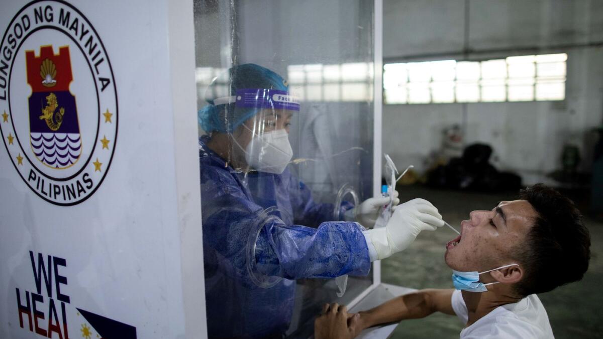 A vendor at Pritil Public Market gets a free swab test amid the coronavirus disease (COVID-19) outbreak, in Tondo, Manila, Philippines, October 8, 2020.