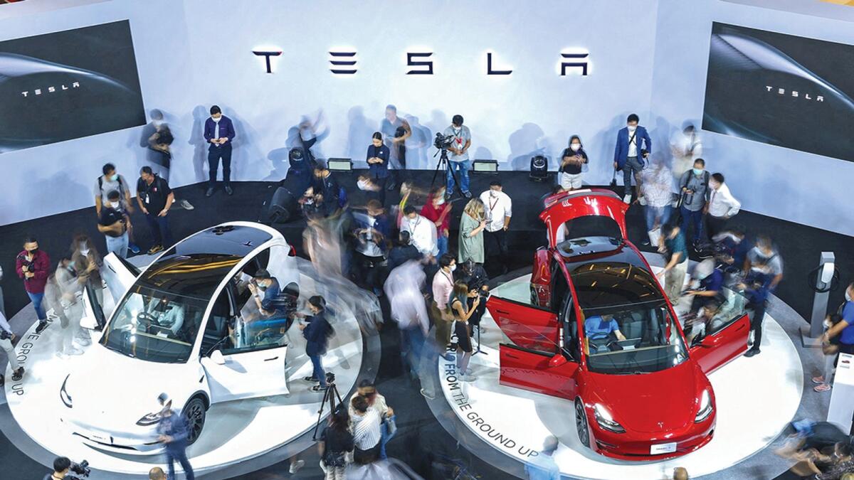 Members of media and guests surround the Tesla Model Y and Model 3 during Thailand Tesla's official launch event in Bangkok, Thailand, December 7, 2022. REUTERS/Athit Perawongmetha