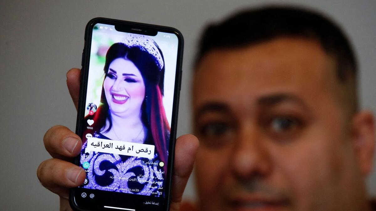 An iraqi man shows a post on a social media platform in the capital Baghdad, with a picture of TikTok celebrity Om Fahed, who has been jailed by the authorities. — AFP