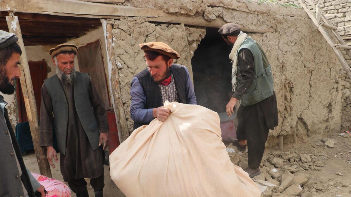 Residents remove their belongings from inside a damaged a house at Sooch village in Jurm district of Badakhshan Province following an earthquake. — AFP