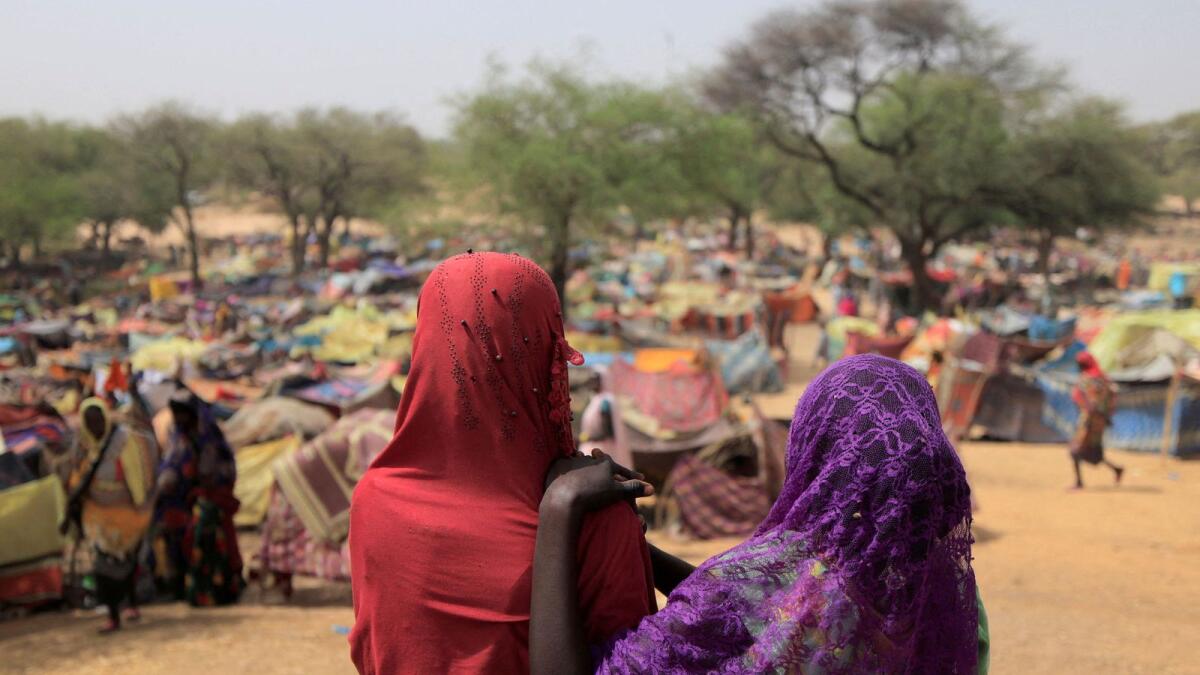 Girls who fled the conflict in Darfur region look at makeshift shelters near the border between Sudan and Chad, while taking refuge in Borota. — Reuters file photo