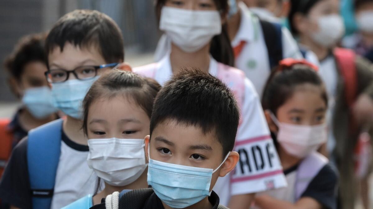 Students wearing face masks to help curb the spread of the coronavirus line-up to enter a primary school in Beijing. Students in the capital city returned to school on Monday in a staggered start to the new school year because of the coronavirus outbreak. Photo: AP