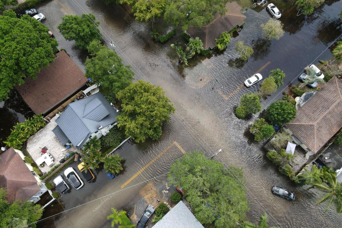 A pair of waterlogged cars sit abandoned in the road as floodwaters recede in the Sailboat Bend neighbourhood of Fort Lauderdale, Florida, on April 13, 2023. Over 25 inches of rain fell in South Florida since April 10, causing widespread flooding. — AP