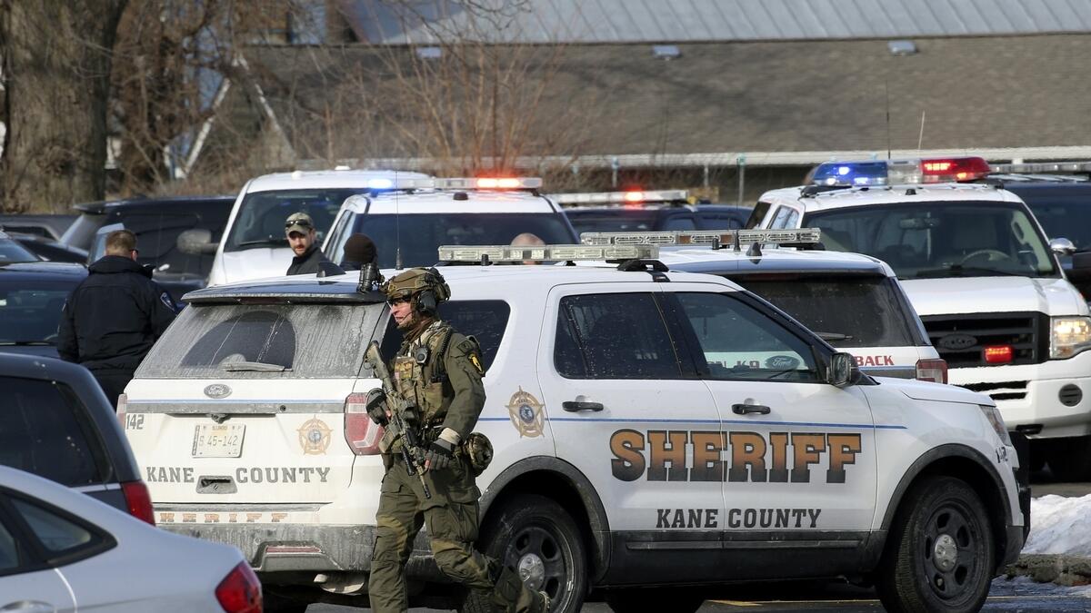 Law enforcement personnel gather near the scene where an active shooter was reported in Aurora, Illinois.- AP