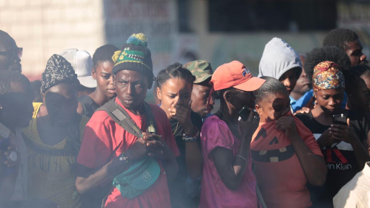 Bystanders look at the bodies of alleged gang members that were set on fire by a mob after they were stopped by police while travelling in a vehicle in the Canape Vert area of Port-au-Prince, Haiti, on Monday. — AP