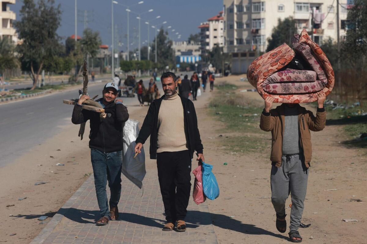 People carrying some of their belongings arrive in Rafah on the southern Gaza Strip on — Thursday. — AFP