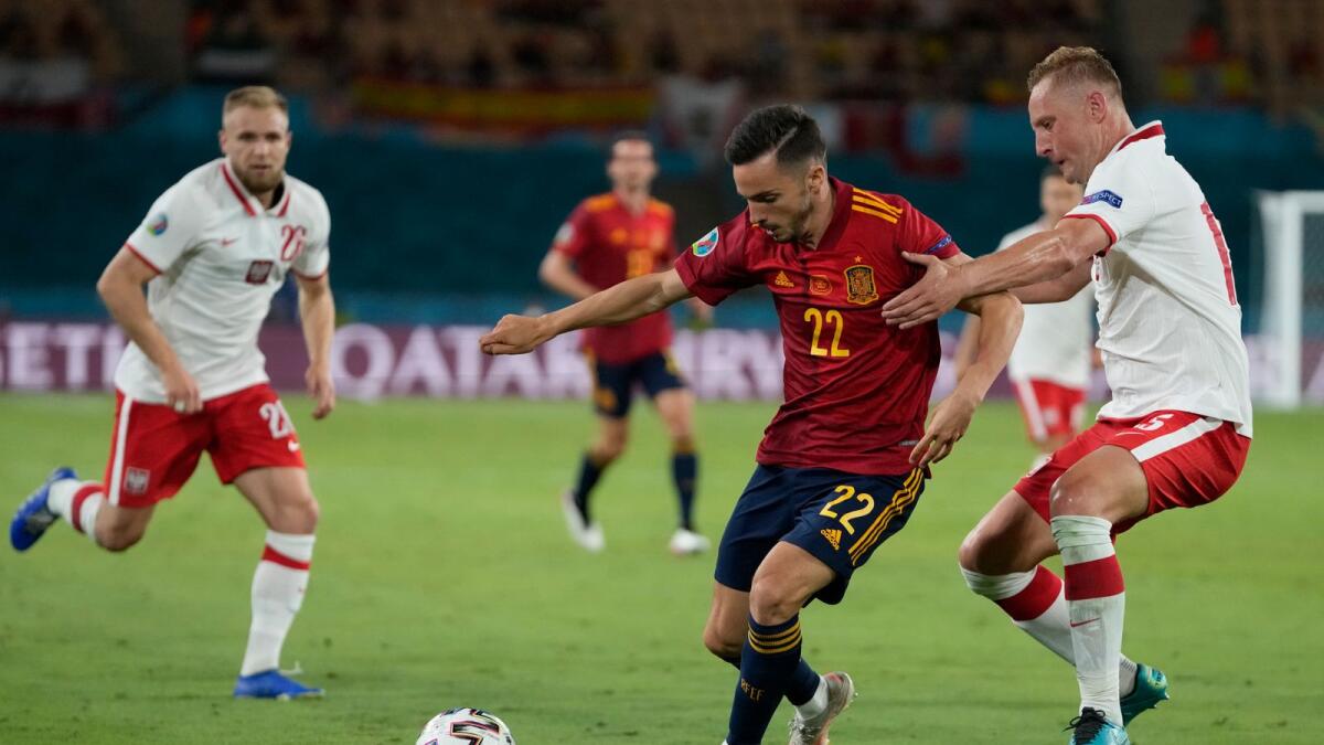 Spain’s Pablo Sarabia (centre) and Poland’s Kamil Glik (right) fight for the ball during the Euro 2020 championship match. — AP