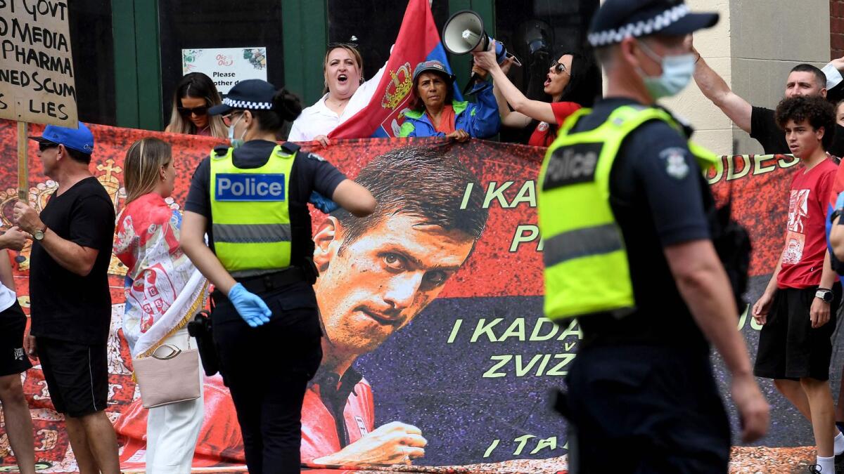 People hold placards at a government detention centre where Novak Djokovic is reported to be staying in Melbourne. (AFP)