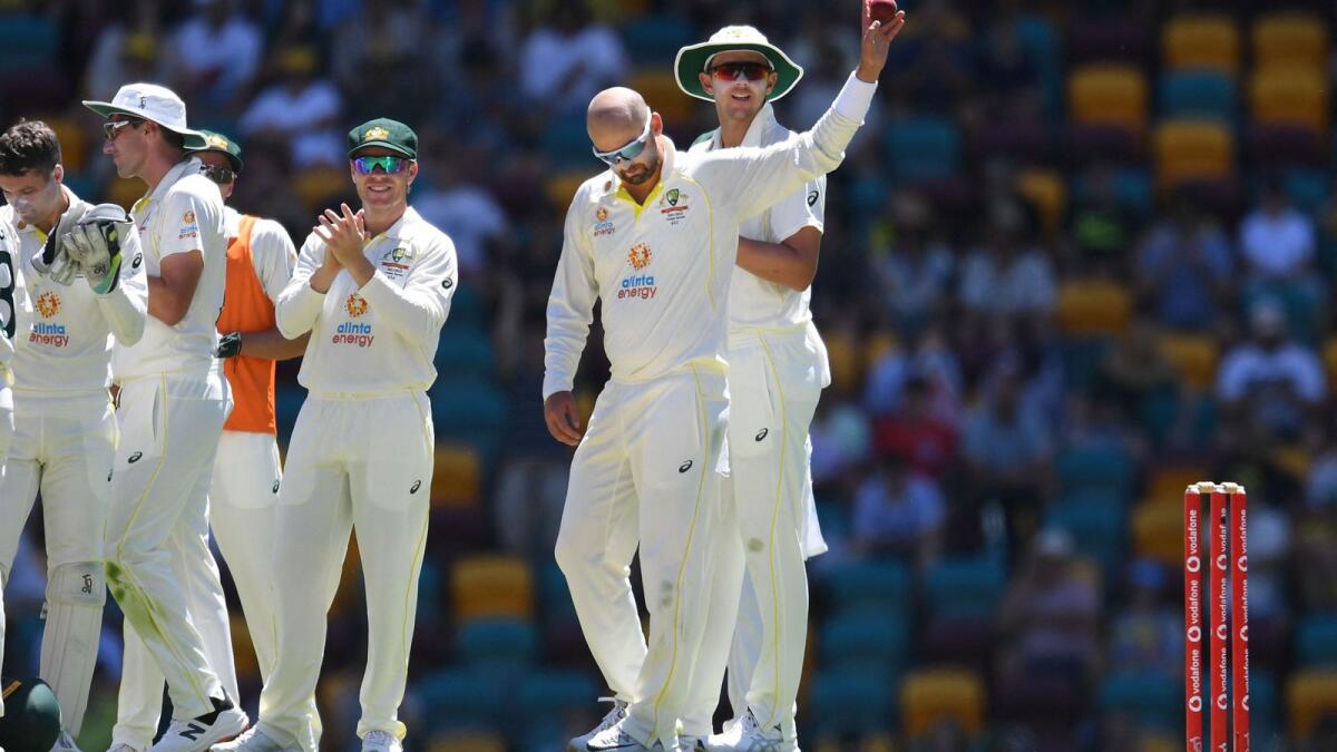 Australia's Nathan Lyon (second from rigth) celebrates with teammates after taking the wicket of England's Dawid Malan, his 400th Test wicket, during day four of the first Ashes Test at the Gabba in Brisbane on Saturday. — AFP