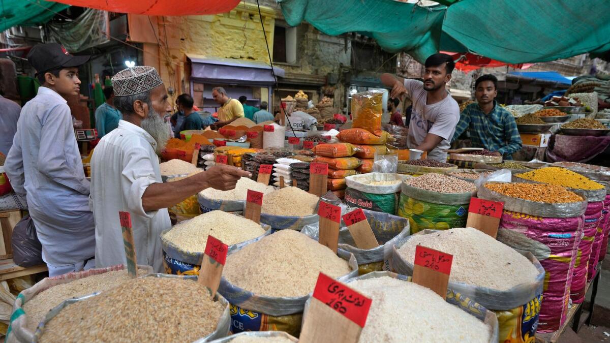 People buy rice and other items at a market, in Karachi. — AP file