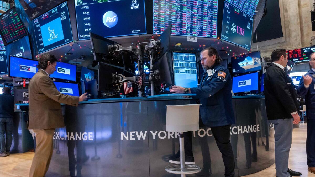 Traders work on the floor of the New York Stock Exchange (NYSE) on the first trading day of 2024 on Tuesday. Stocks were lower in morning trading as investors come of an unexpected strong year in stocks and the American economy overall.  — AFP