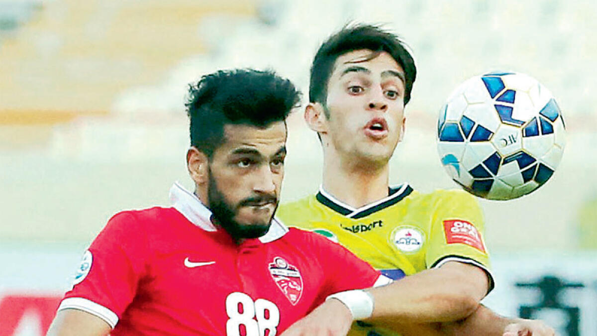 Naft’s Arash Rezavand (right) vies for the ball with Al Ahli’s Majed Hassan during their AFC Champions League quarterfinal in Tehran. 