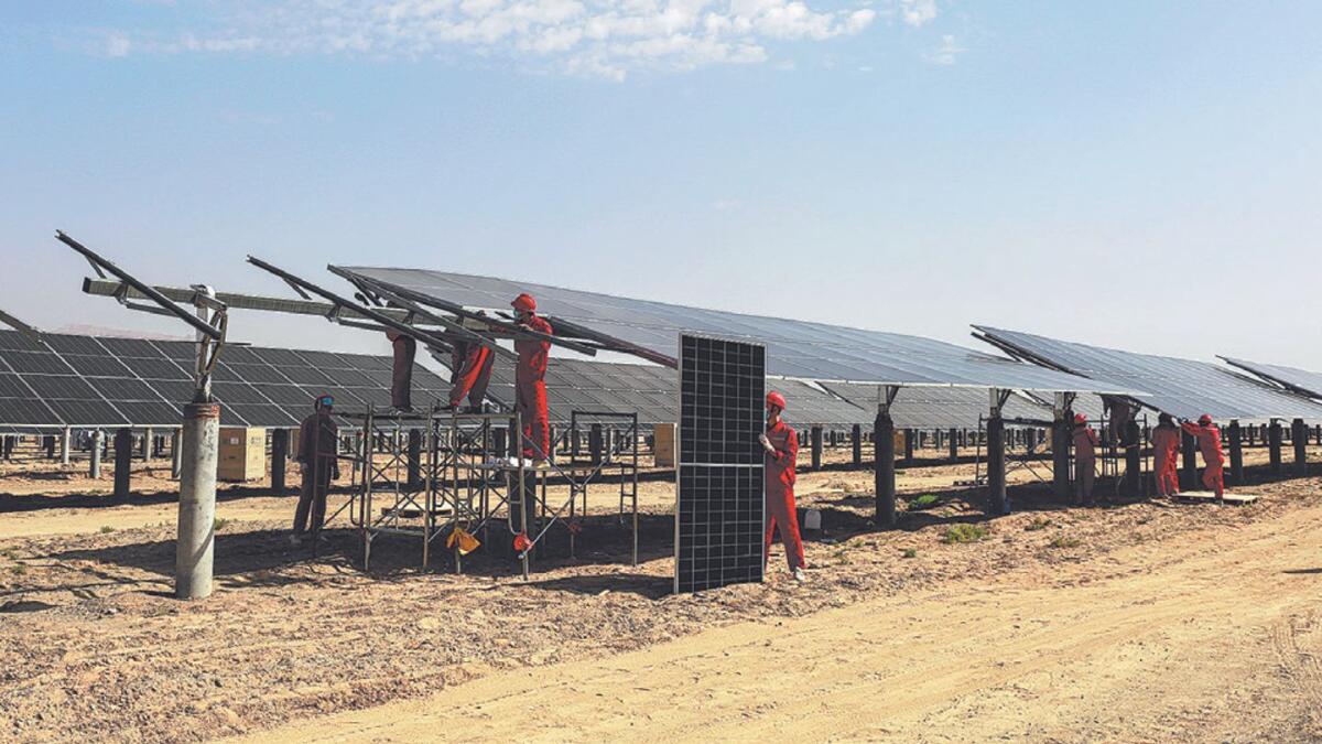 Workers install photovoltaic panels in Aksu, Xinjiang Uygur autonomous region, in September. Provided to China Daily