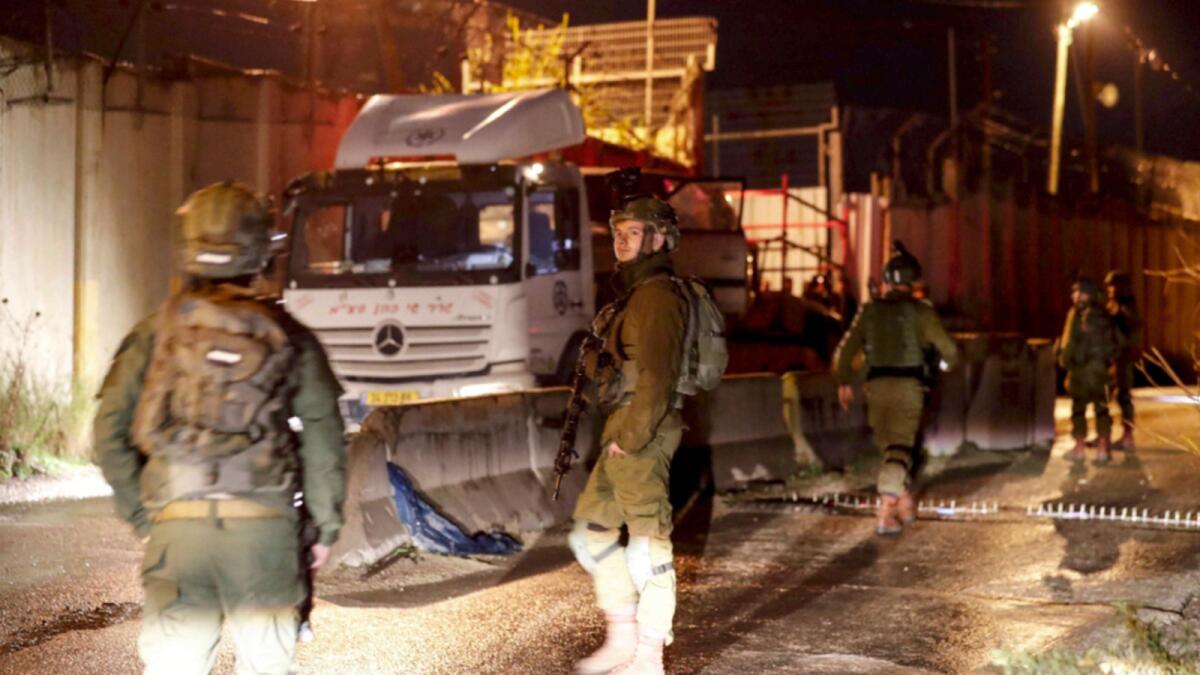 Members of the Israeli security forces surround a truck near the settlement of Shavei Shomron, that was brought to the scene to carry away a car in which three Israelis came under gunfire. — AFP