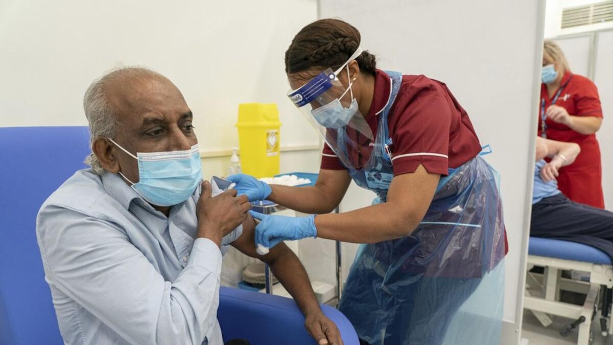 Care home worker Pillay Jagambrun, 61, receives the Pfizer/BioNTech Covid-19 vaccine in The Vaccination Hub at Croydon University Hospital, south London, onTuesday Dec. 8, 2020.