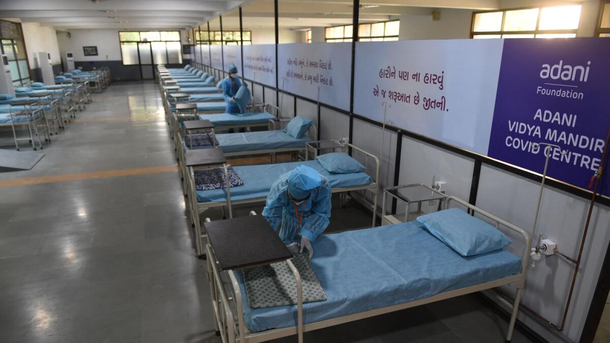 Caretakers arrange beds at the Adani Vidya Mandir school which has been converted into a Covid care centre in Ahmedabad. Photo: AFP
