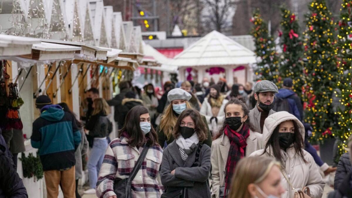 Shoppers wearing face masks to protect against Covid-19 walk along the Christmas market at Tuilerie garden in Paris. — AP