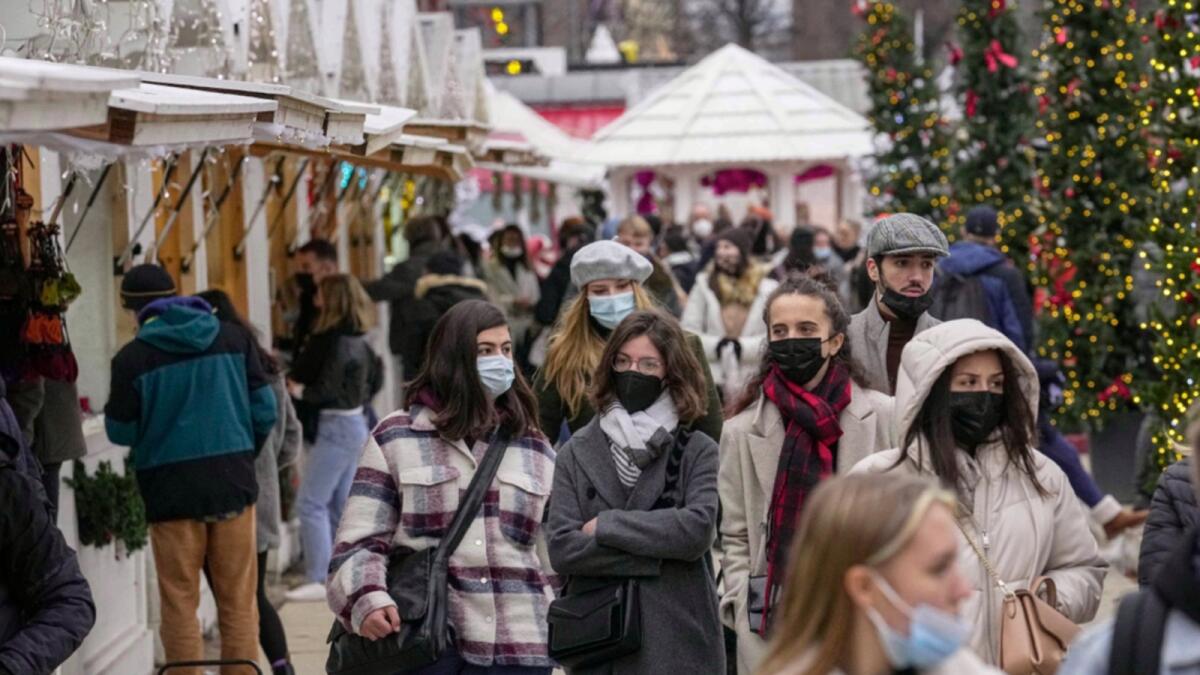 Shoppers wearing face masks to protect against Covid-19 walk along the Christmas market at Tuilerie garden in Paris. — AP