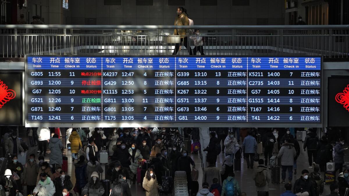 Travellers walk through a trains departure board at the West Railway Station in Beijing on Jan. 15, 2023. China has announced its first overall population decline in recent years amid an aging society and plunging birthrate. Photo: AP