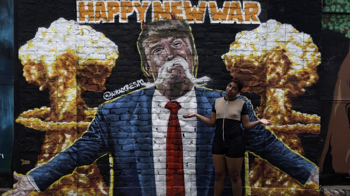 A youth poses next to graffiti art depicting U.S President Donald Trump in Rio de Janeiro, Brazil, November 6, 2020.