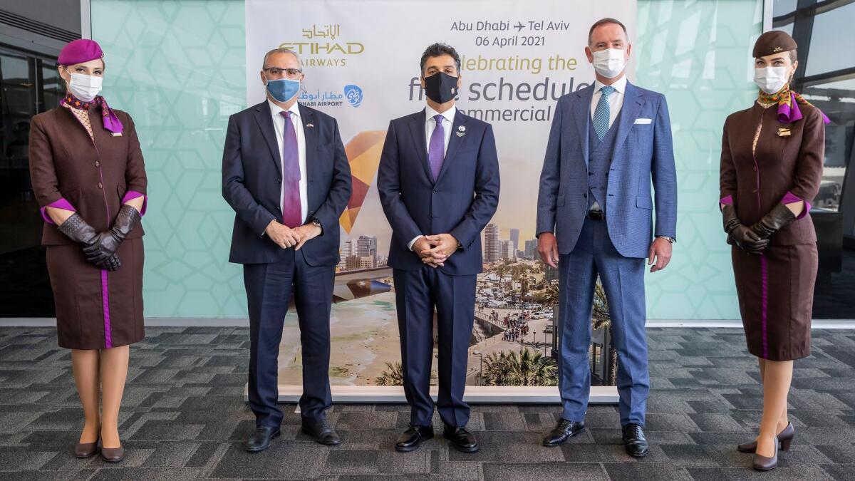 (From left): Eitan Nae’eh, Israel’s Head of Mission to the UAE; Mohamed Al Khaja, UAE’s first Ambassador to Israel; and Tony Douglas, Group CEO, Etihad Airways, with the national carrier’s cabin crew at the start of the scheduled flights to Israel on Tuesday. Supplied Photo
