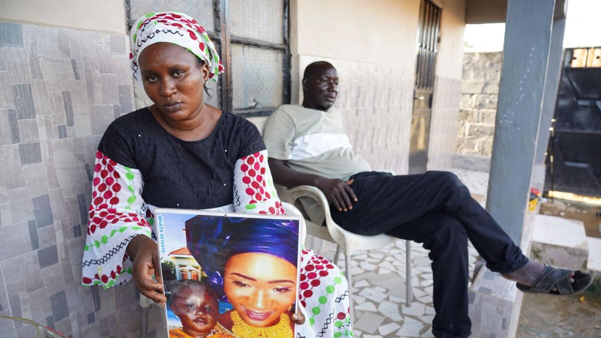 A woman holds up a picture of her late son who died from acute kidney failure in  Gambia. –AFP