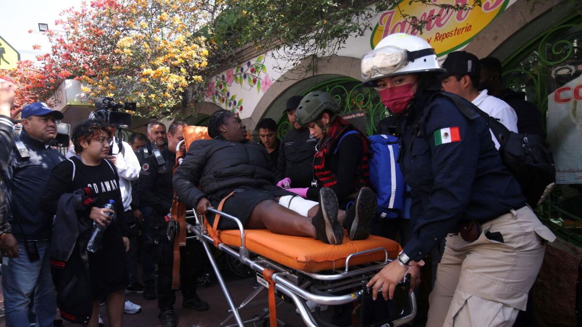 Paramedics assist a woman after two subway trains collide head-on at a subway station, in Mexico City. — Reuters