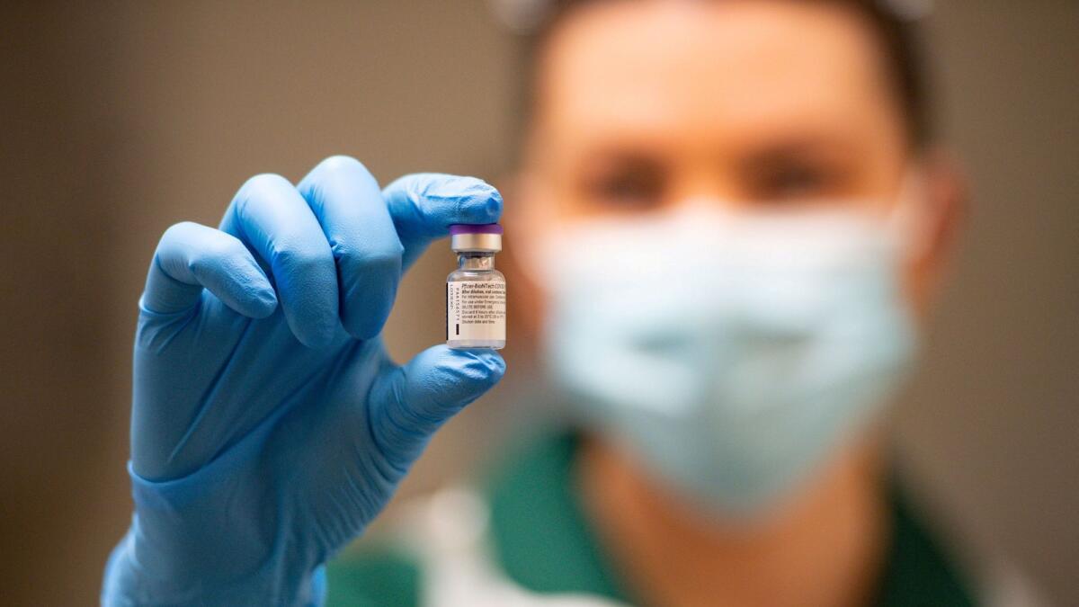 A nurse holds a phial of the Pfizer/BioNTech COVID-19 vaccine at University Hospital in Coventry, December 8.