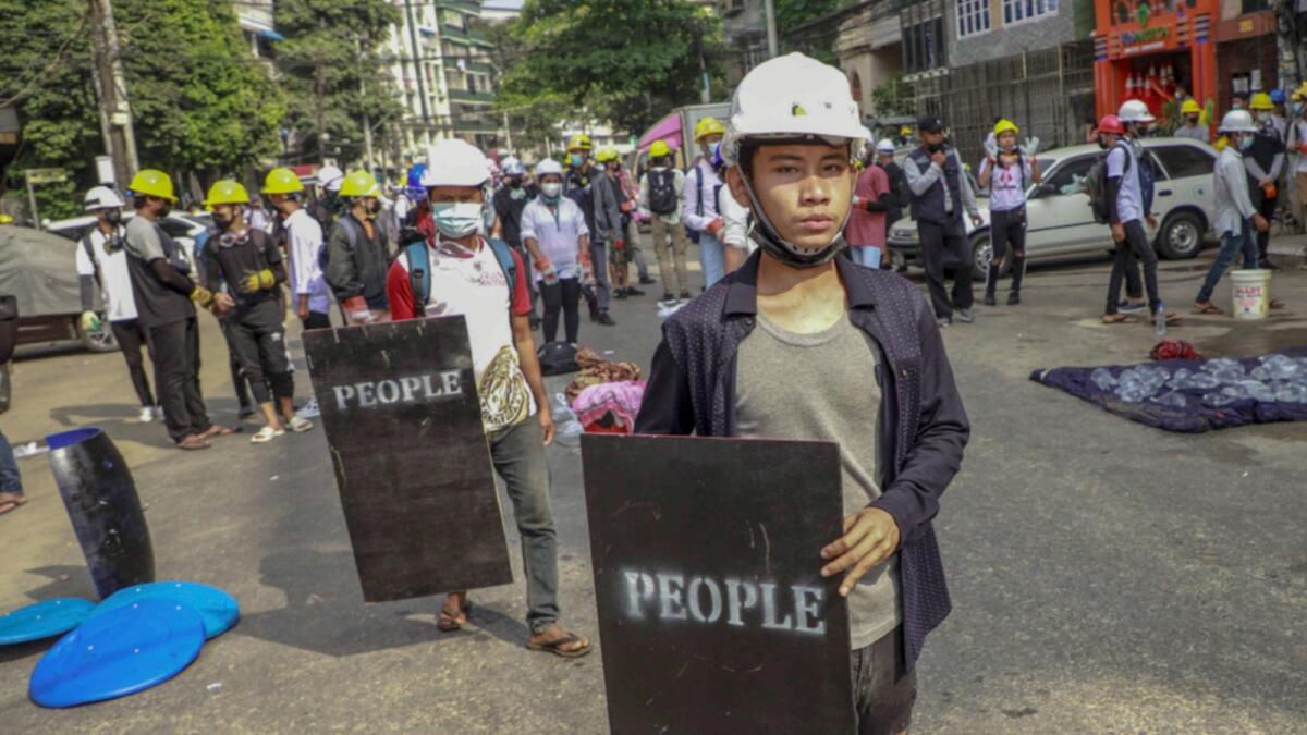 Anti-coup protesters with makeshift shields stand during a rally in Yangon, Myanmar. — AP