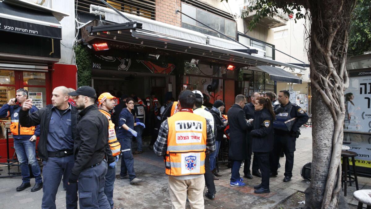 Members of the Israeli security forces stand outside a pub following an attack by an unidentified gunman who opened fire killing two people and wounding five others in the Israeli city of Tel Aviv.