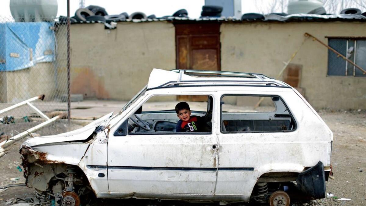 LEST WE FORGET: A Syrian refugee boy plays inside a ruined car at an informal refugee camp, at Al Marj town in Bekaa valley, east Lebanon. 